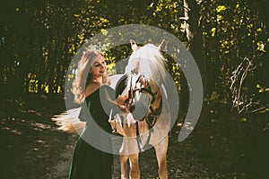 Woman with a horse at forest, mystical scene