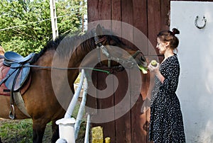 Woman with horse in stable at countryside ranch. Girl horse rider in summer outdoor. Equestrian and horseback riding. Horse