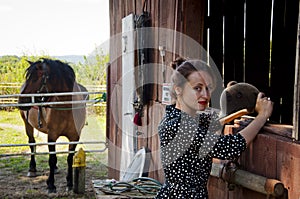 Woman with horse in stable at countryside ranch. Girl horse rider in summer outdoor. Equestrian and horseback riding. Horse