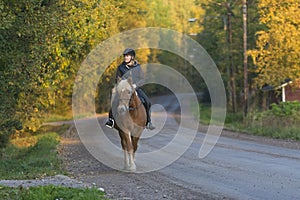 Woman horseback riding in sunset photo