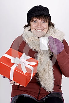 Woman with hot beverage and christmas present