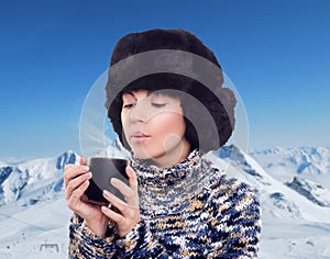 Woman with hot chocolate on the snowy mountains, winter season