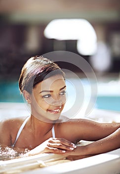 Woman, hot tub and spa relax at resort with smile thinking for stress relief, holiday or travel. Female person, jacuzzi