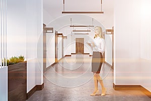 Woman in hotel corridor with closed doors