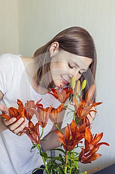Woman of the house inhales the scent of orange lilies standing