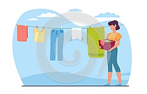 Woman housewife hangs washed laundry on clothesline. Clothing hanging on rope. Underwear and garments attached with