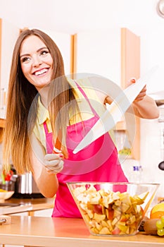Woman housewife in kitchen cutting apple fruits