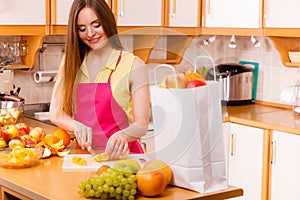 Woman housewife in kitchen cutting orange fruits