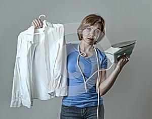 Woman or housewife sad bored and stressed holding white shirt and iron angry and frustrated