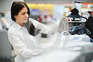 Woman housewife shopping for iron, smiling