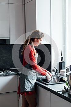 woman housewife washes dirty dishes in the kitchen