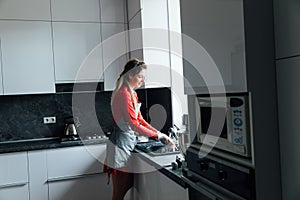 woman housewife washes dirty dishes in the kitchen