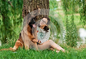 Woman hug her dog German Shepherd in summer park