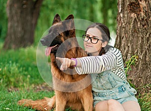 Woman hug her dog German Shepherd in summer park