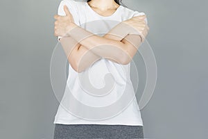 Woman hugged herself isolated on gray background