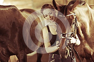 Woman hugging brown horse in stable