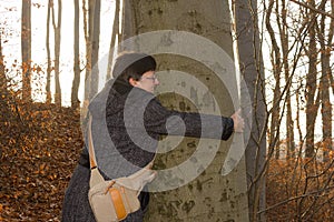 Woman hugging a tree.