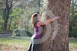 woman hugging a tree in the park