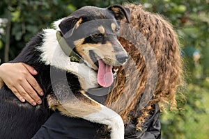 A woman hugs a dog in autumn
