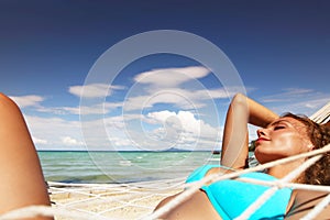 Woman in hummock on tropical beach
