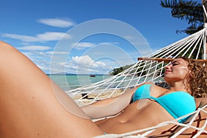 Woman in hummock on tropical beach