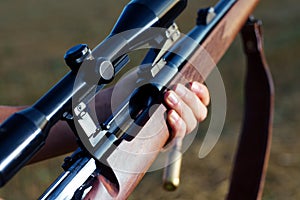 Woman hunter loading bullet to carbine