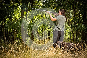 Woman hunter in the woods - taking the shot