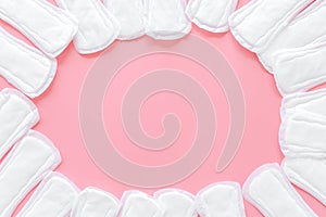 Woman hygiene and menstrual period concept with sanitary pads frame on pink background top view copyspace photo