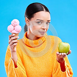 Woman, ice cream and apple with choice in portrait for health, wellness and diet by blue background. Girl, model and