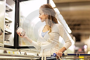 Woman with ice cream at grocery store freezer photo