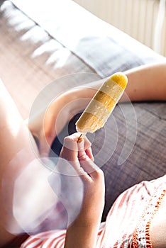 woman; ice-cream; leisure; eating; at home; sofa; lounge; stick;