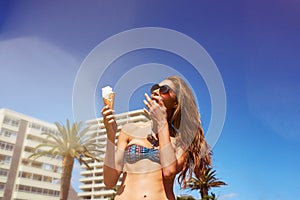 Woman, ice cream and lick fingers outdoor with blue sky mockup space on summer vacation alone. Gelato, food and person