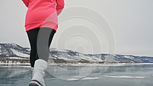 Woman on ice in winter is do sport in athletic race walking. Girl is training in winter on ice. Sports nordic power