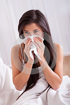 Woman ill in bed with a cold and flu