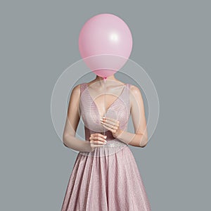 woman im evening dress. Hides her face behind pink balloon