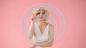 The woman in the image of Marilyn Monroe raised her index finger up, there is an idea. Woman with bright makeup in white