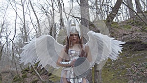 Woman in image of warlike Valkyrie with wings holding weapon and shield