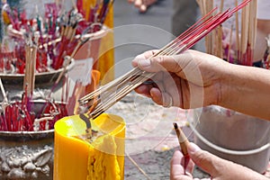 The woman is incensing bundle of joss stick