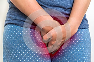 Woman with incontinence problem is holding her crotch