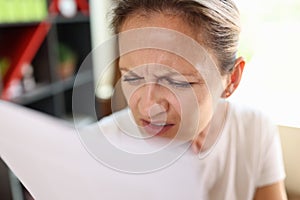 Woman with incredulous face reading documents close up. photo