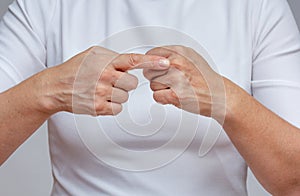 Woman index finger pointing at the second digital knuckle on hand to identifying Arthritis