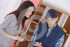 Woman indoors with contractor holiding clipboard