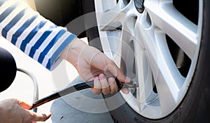 Woman inflates the tire. Woman checking tire pressure and pumping air into the tire of car wheel. Car maintenance service for