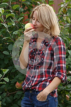 Woman inhales aroma of an apple