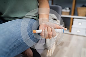 Woman Injecting Epinephrine Using Auto-injector Syringe photo