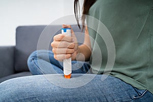 Woman Injecting Epinephrine Using Auto-injector Syringe photo