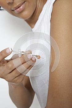 Woman Injecting Insulin Using Syringe photo