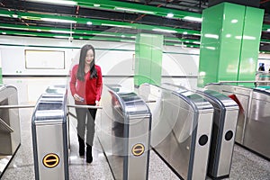 Woman insert ticket to ticket entrance train station