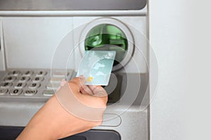 Woman inserting credit card into cash machine, closeup