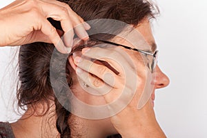 Woman inserting a hearing aid